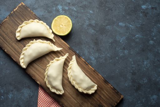A top view of dumplings with lemon on a chopping board