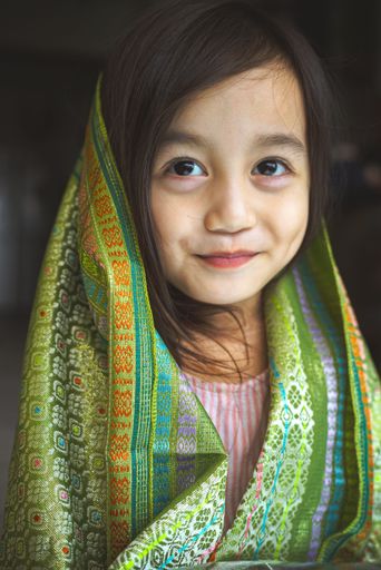A vertical shot of a beautiful small girl smiling