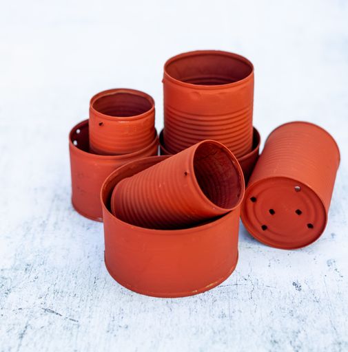 A high angle view of red cans in different sizes on the table under the lights