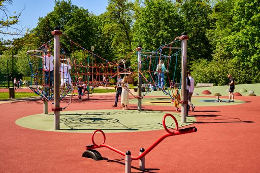 A beautiful shot of Children playing on equipment at a playground in the Wodziczki park on a sunny day