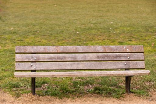 A closeup shot of an old wooden bench in the park