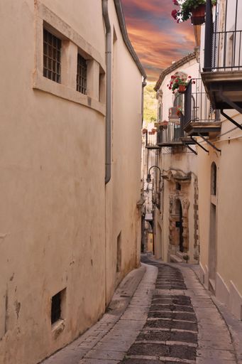 A narrow street in the old town of Modica in Sicily, Italy
