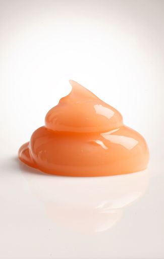 A vertical shot of an orange skincare cream drop texture - advertising