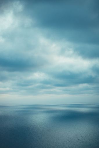 A vertical shot of a gloomy sky over a blue sea