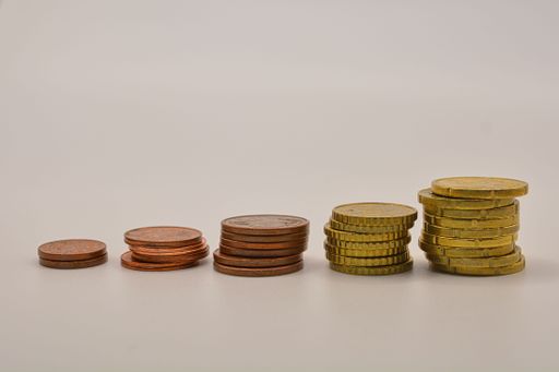 A closeup shot of five stacks of coins arranged every type on each other on isolated background