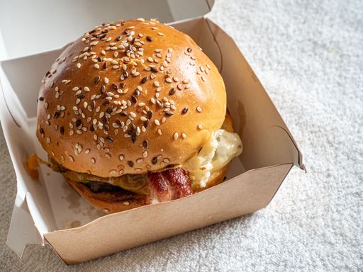A delicious Burger with bacon in a box