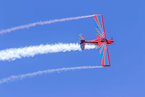 The red and blue plane flying in the blue sky at the air show. Orlando Sanford International Airport.