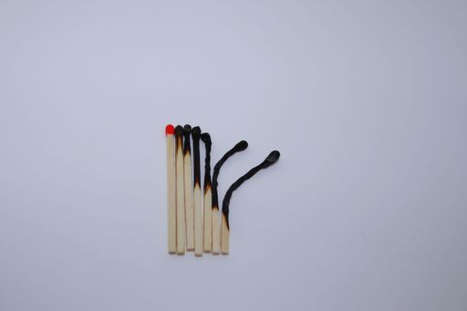 A top view of a set of burnt matches at different stages isolated on white background