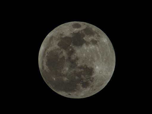 A closeup shot of a full moon before the lunar eclipse on a black sky background