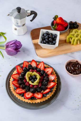 A vertical shot of a delicious tart decorated with exotic fruits