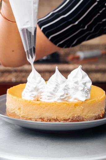 A vertical shot of a yummy lemon cake decorated with whipped cream