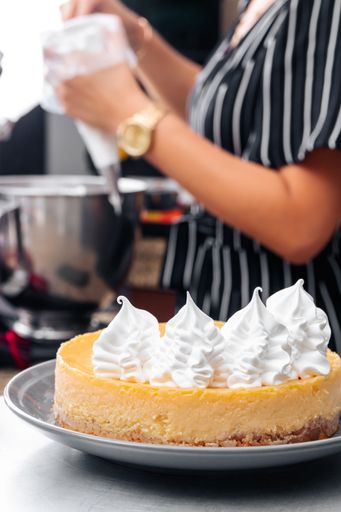 A vertical shot of a yummy lemon cake decorated with whipped cream