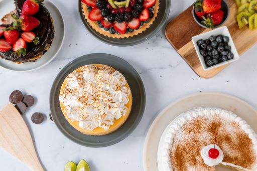 A top view of various delicious cakes on the white surface