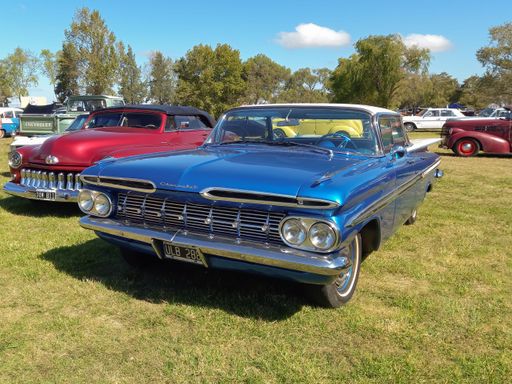 old popular blue Chevrolet Chevy Biscayne four door sedan 1960 by GM in the countryside. Nature grass and trees. Classic car show. Copyspace