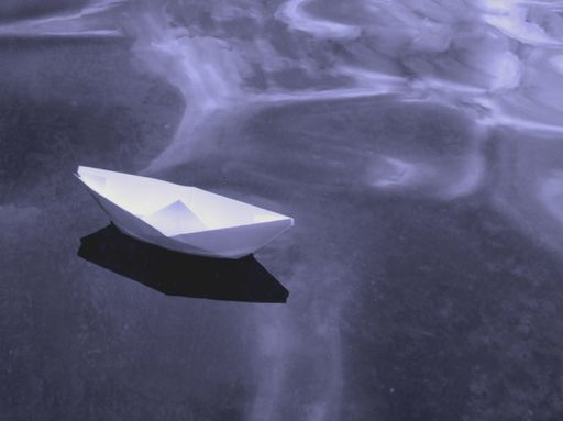 A closeup of a small paper boat on a water