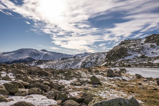 A beautiful scenery of a snow-covered landscape with rocky cliffs under a cloudy sky