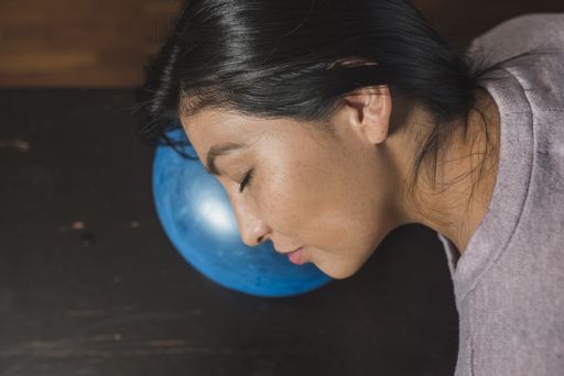 A closeup shot of a young Hispanic female with long black hair relaxing on a blue balloon