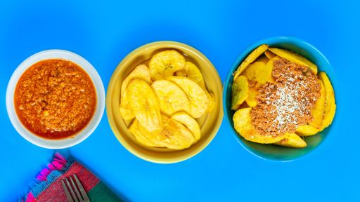 An overhead shot of Honduran Carne con tajadas, meat with plantain chips on a blue surface