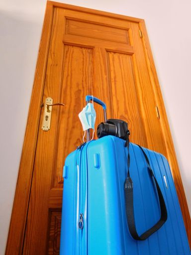 The concept of traveling with a suitcase with a photographic camera during coronavirus pandemic