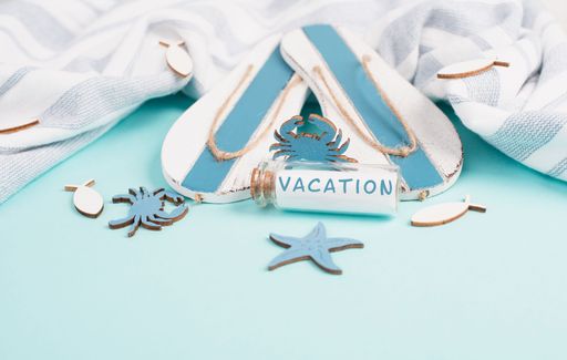 Blue colored summer and vacation background, flippers, sea stars and a glass bootle with the word holiday, travel and tourism concept