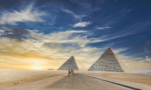 A beautiful view of Egyptian pyramids under a cloudy sunset sky