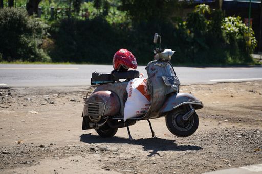 A vintage Vespa motorbike on the side of the highway in Jawa Tengah, Indonesia