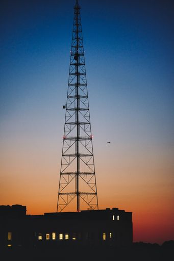 A vertical shot of a cell tower during a scenic sunset