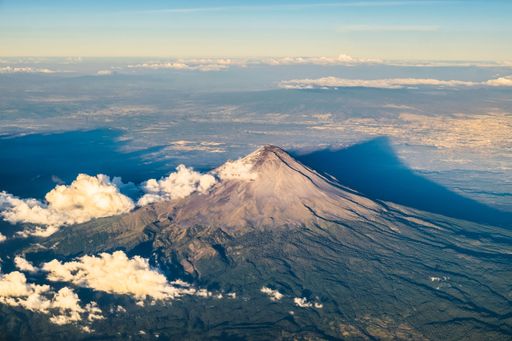 An aerial view of volcano Popocatepetl under blue sky