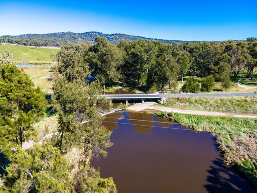 The muddy Severn River under a bridge surrounded with greenery in New South Wales, Australia