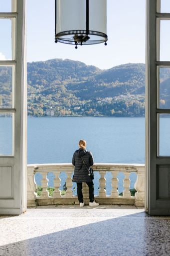 A rear view of a female enjoying a beautiful view of lake Como