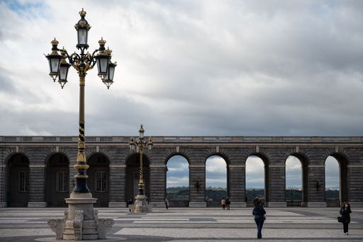 The courtyard of the royal palace in Madrid with an aesthetic street lamp under a sky with clouds