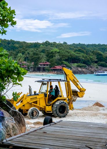 With an excavator, the process of reconstructing and improving a sandy beach.