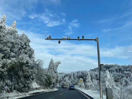 A scenic view of a highway surrounded by fir forests covered by snow