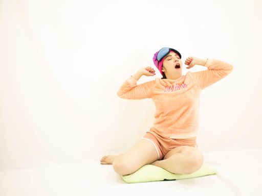 A young woman yawning on the white background