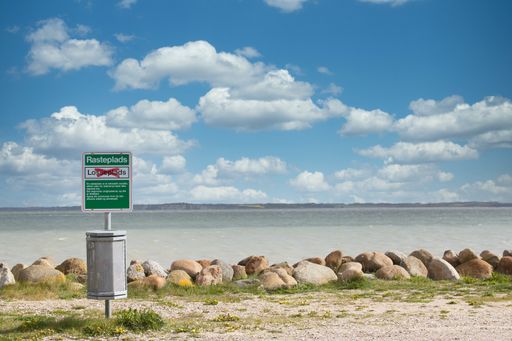 A closeup of a garbage bin on a beach in Denmark