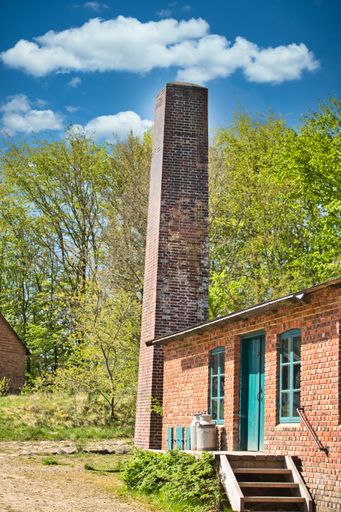 A vertical shot of a dairy with a chimney