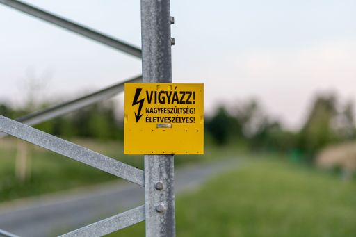 A close-up shot of a high voltage banner pasted on a metallic construction.