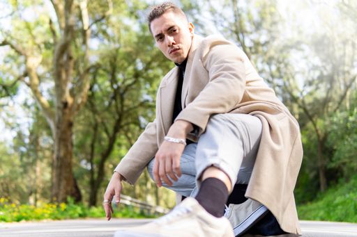 Young hispanic arab man posing in the road looking at camera, copy space