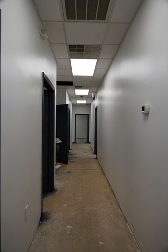A vertical shot of a building hall with open office doors