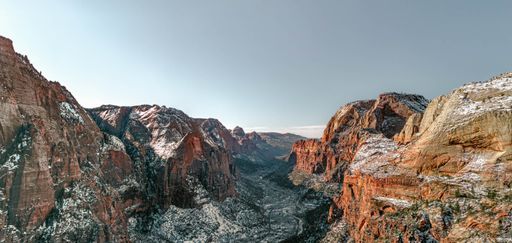 A view of snow covered mountain rocks under blue bright sky
