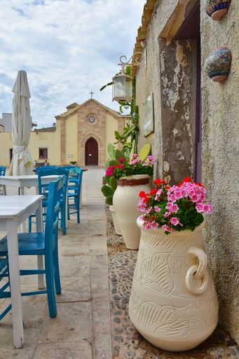 A vertical shot of tables of an outdoor restaurant in Marzameni, a village in Sicily, Italy