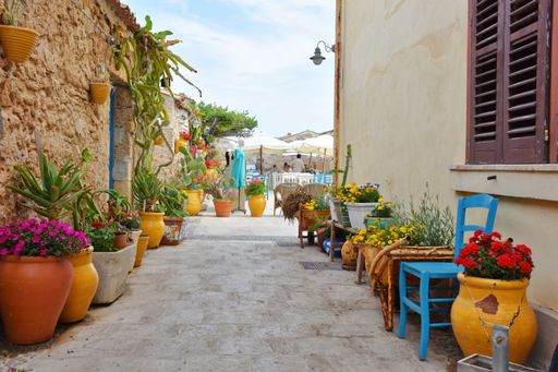 A closeup shot of tables of an outdoor restaurant in Marzameni, a village in Sicily, Italy