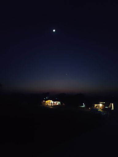 A night view of two illuminated houses under the moonlight in Mahkhor, Madhya Pradesh, India