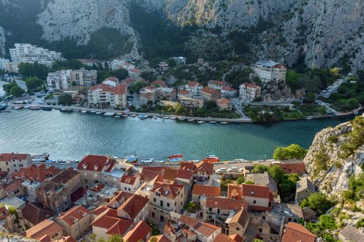 An aerial view of cityscape Omis surrounded by buildings and Cetina river
