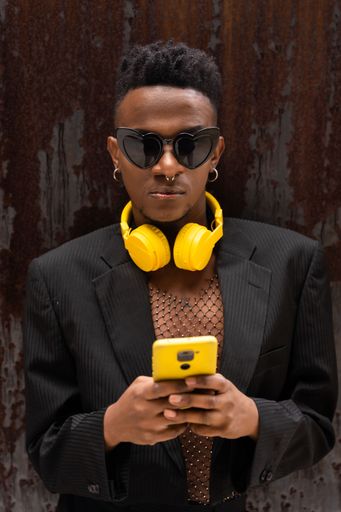 A closeup of a black ethnic man listening to music in yellow headphones
