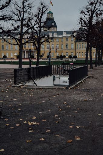A vertical shot of an underground metro entrance with the Karlsruhe Palace in the background, Germany
