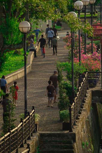 A vertical shot of people walking in the park in Kuching, Sarawak, Malaysia