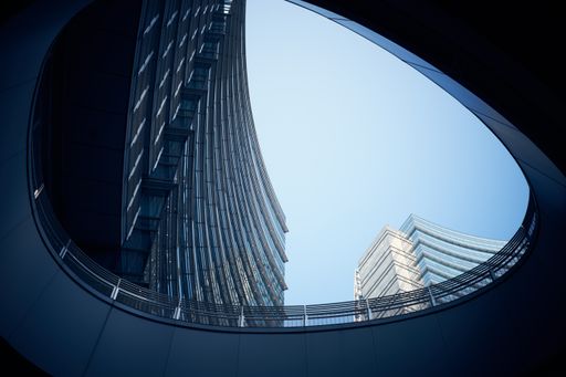 A low angle shot of modern curtain wall business buildings shot from an underground passage during the day. Perfect for modern urban scenarios.