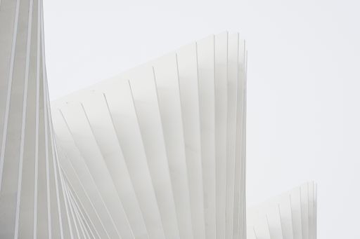 A horizontal shot abstract buildings with white metallic ribs and glass windows. Perfect for an abstract wallpaper or a background.