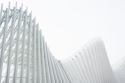 A horizontal shot abstract buildings with white metallic ribs and glass windows. Perfect for an abstract wallpaper or a background.